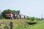 A northbounc grain train approaches a small crossing